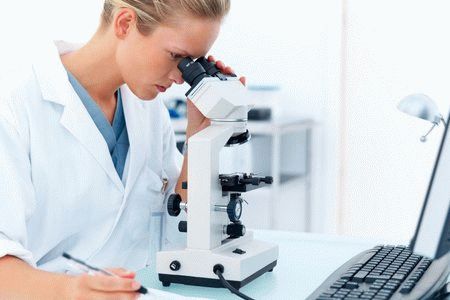 врач смотрит в микроскоп